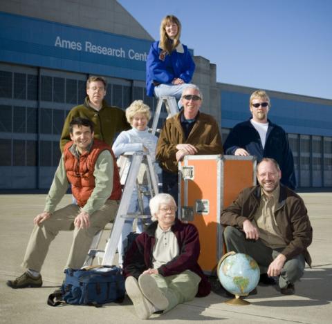 A group of scientists standing together on a tarmac.